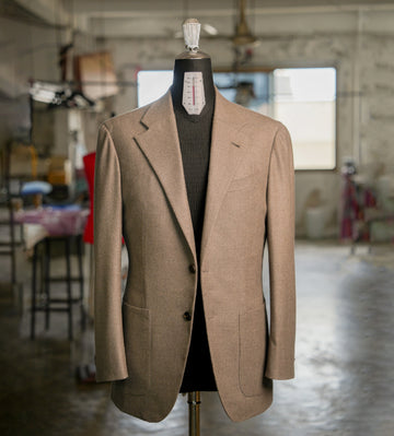 Brown blazer on a mannequin in a workshop setting