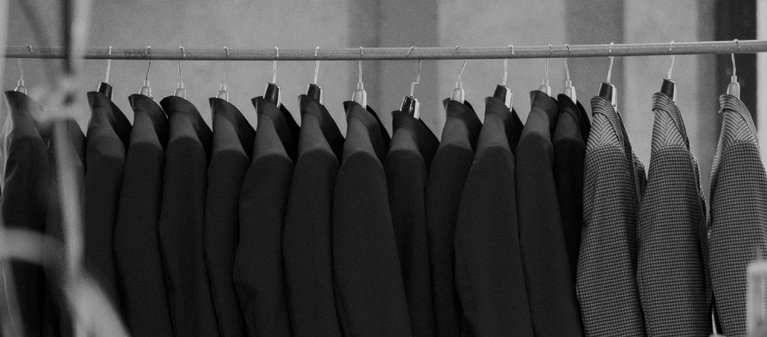 Black shirts on hangers in a row.