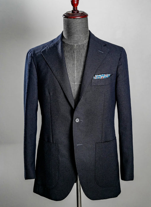 Navy blazer on a mannequin against a gray background