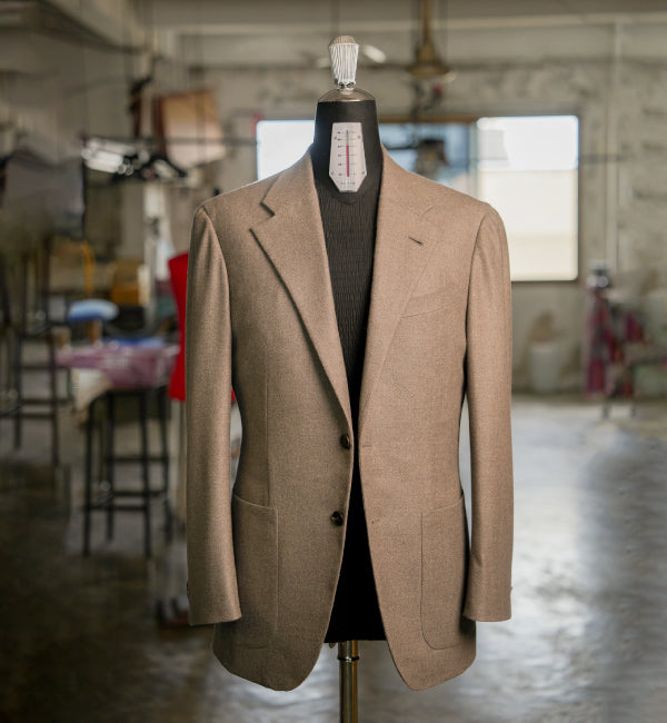 Brown blazer on a mannequin in a workshop setting