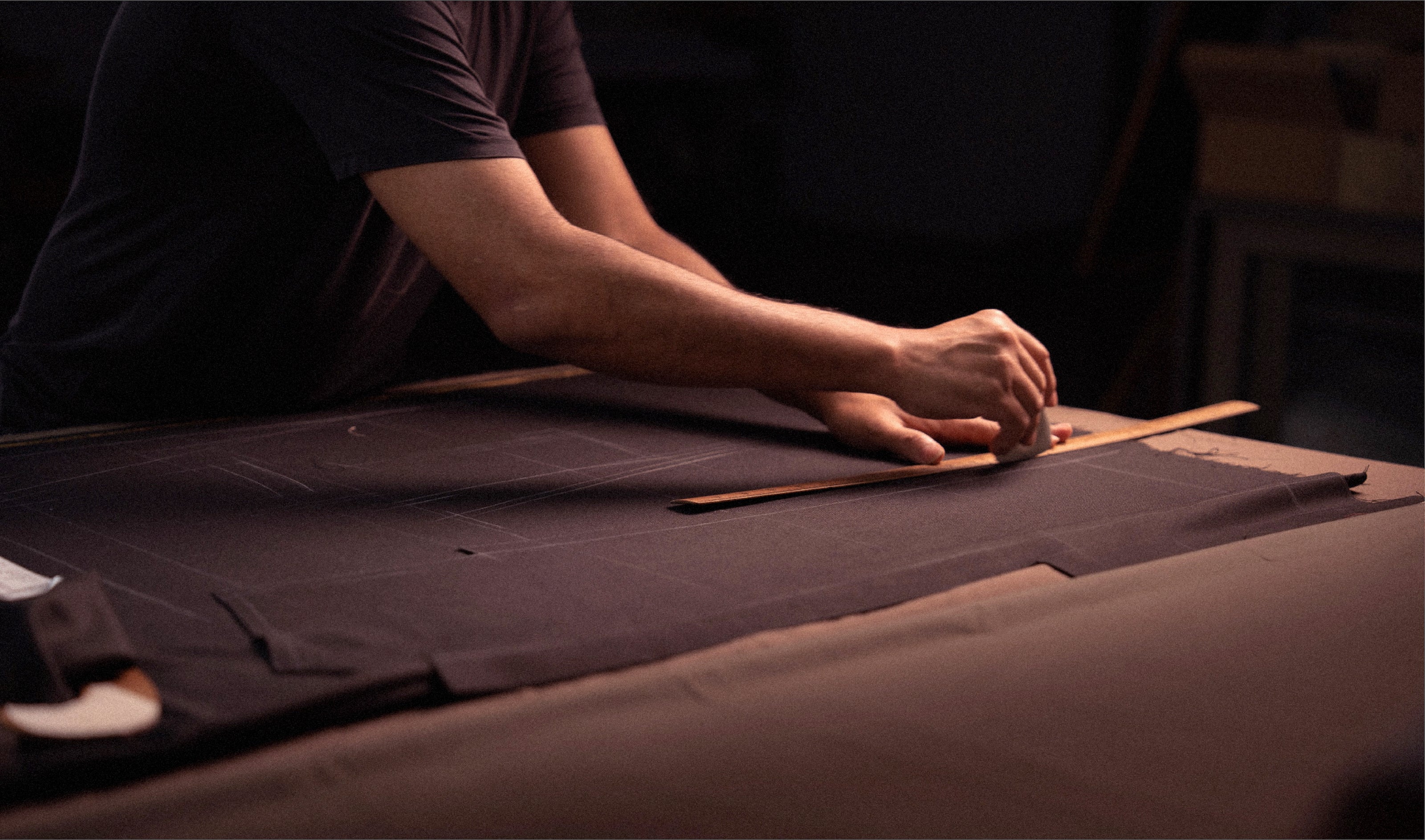 Person working with leather on a dark surface
