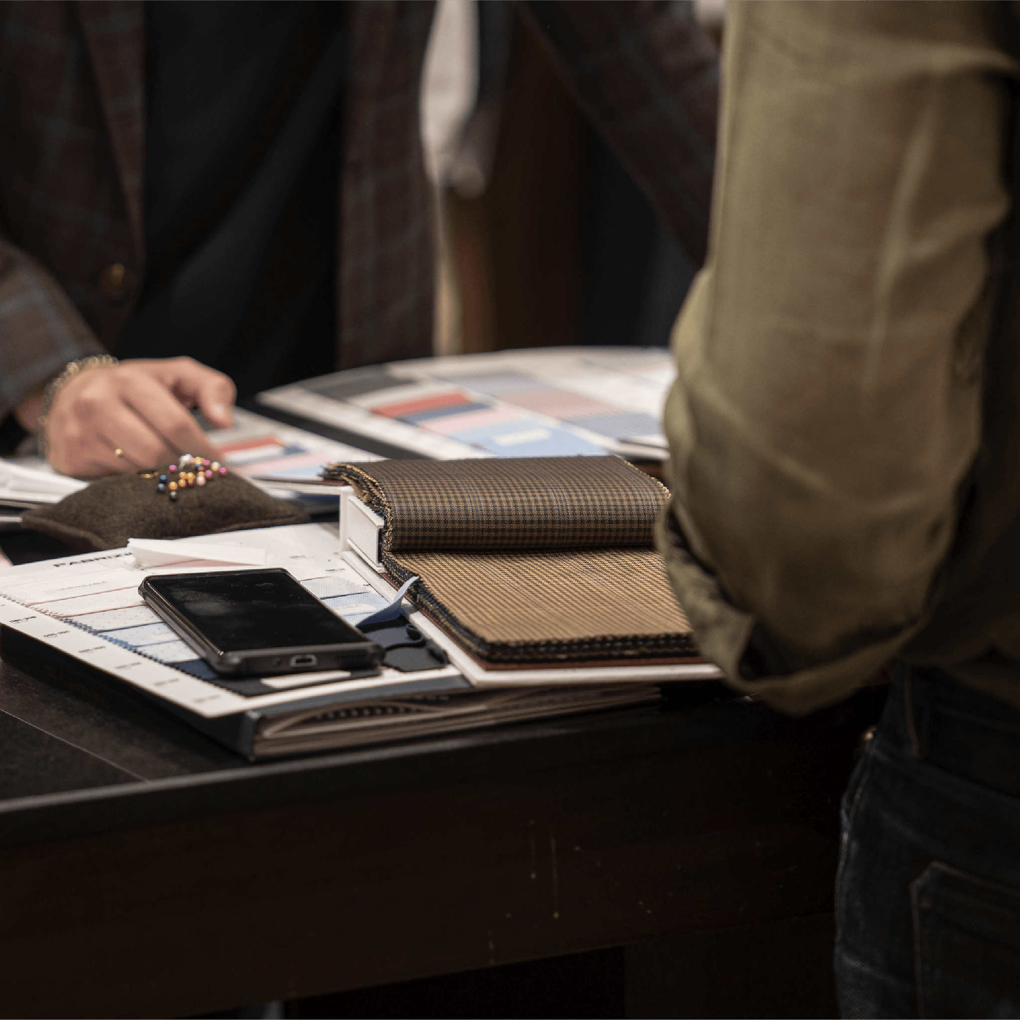 Person interacting with a table displaying various items including a phone and wallets.