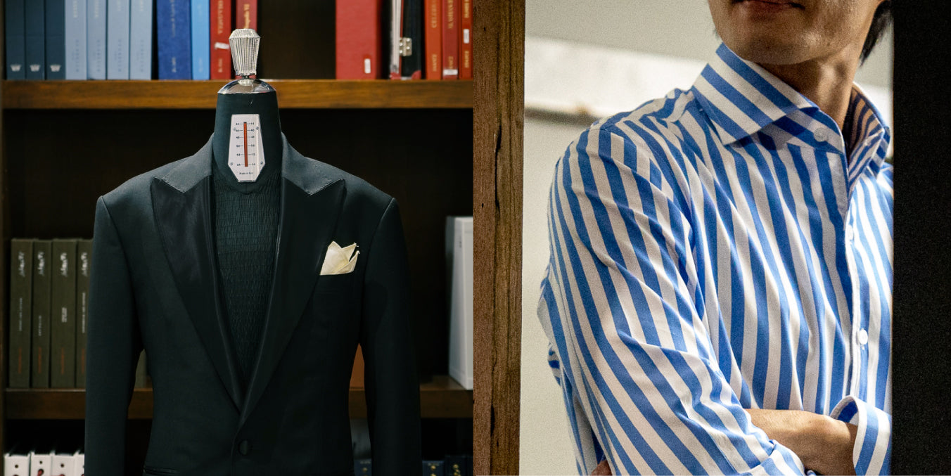 Mannequin wearing a dark suit with a white pocket square, next to a person wearing a blue and white striped shirt.